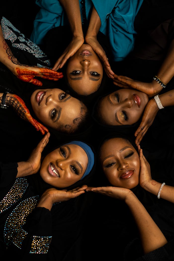 A group of smiling women lying in a circle, symbolizing sisterhood and happiness.