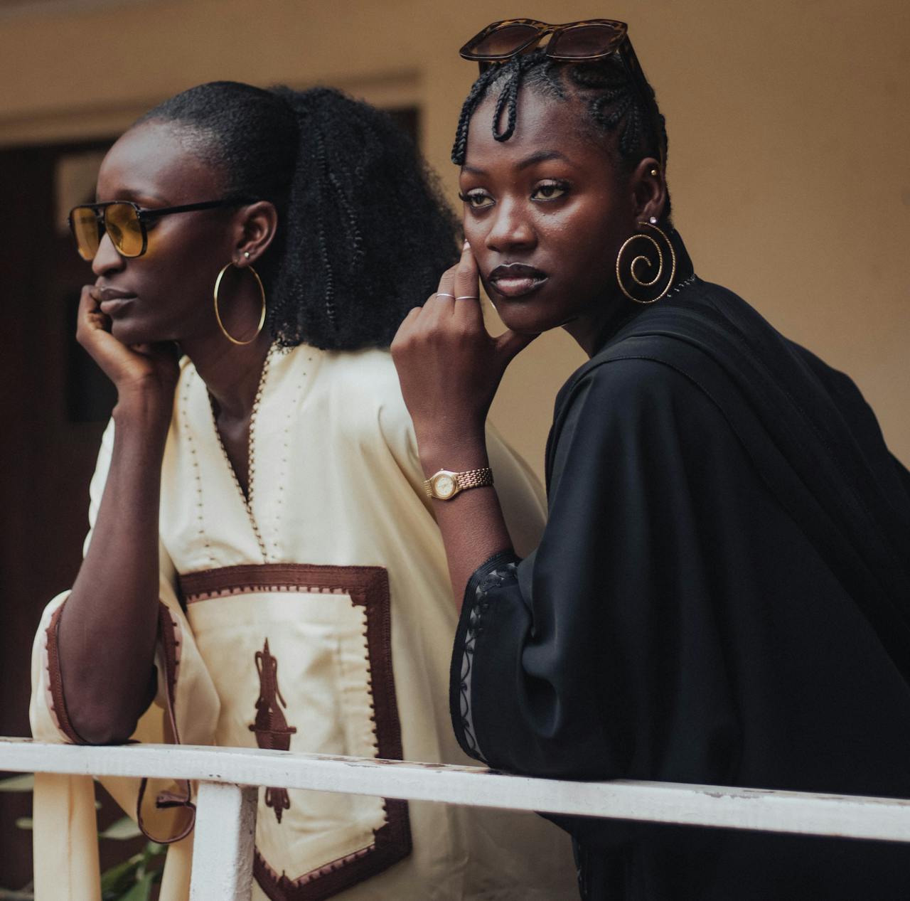 Two stylish women pose with elegance and confidence, showcasing cultural fashion.
